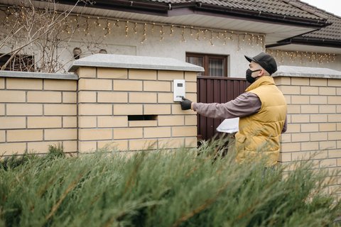 Homeowner pressing an intercom panel similar to the HP7 outdoor unit
