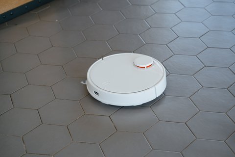 Robot vacuum cleaning a tiled floor similar to the EZVIZ RE4 in use