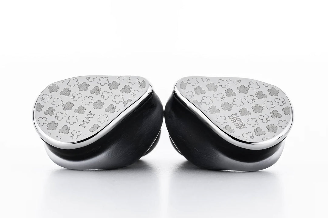 Moondrop May earpieces facing each other with clover engraving detail Moondrop May earpieces facing each other with clover engraving detail