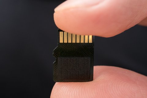 MicroSD card held between two fingers MicroSD card held between two fingers