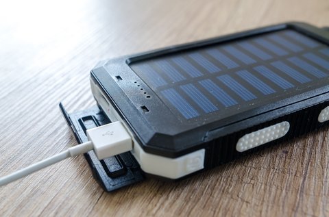 Compact power bank charging a smartphone with a cable Compact power bank charging a smartphone with a cable