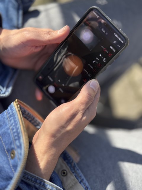 Person using a smartphone camera app outdoors Person using a smartphone camera app outdoors