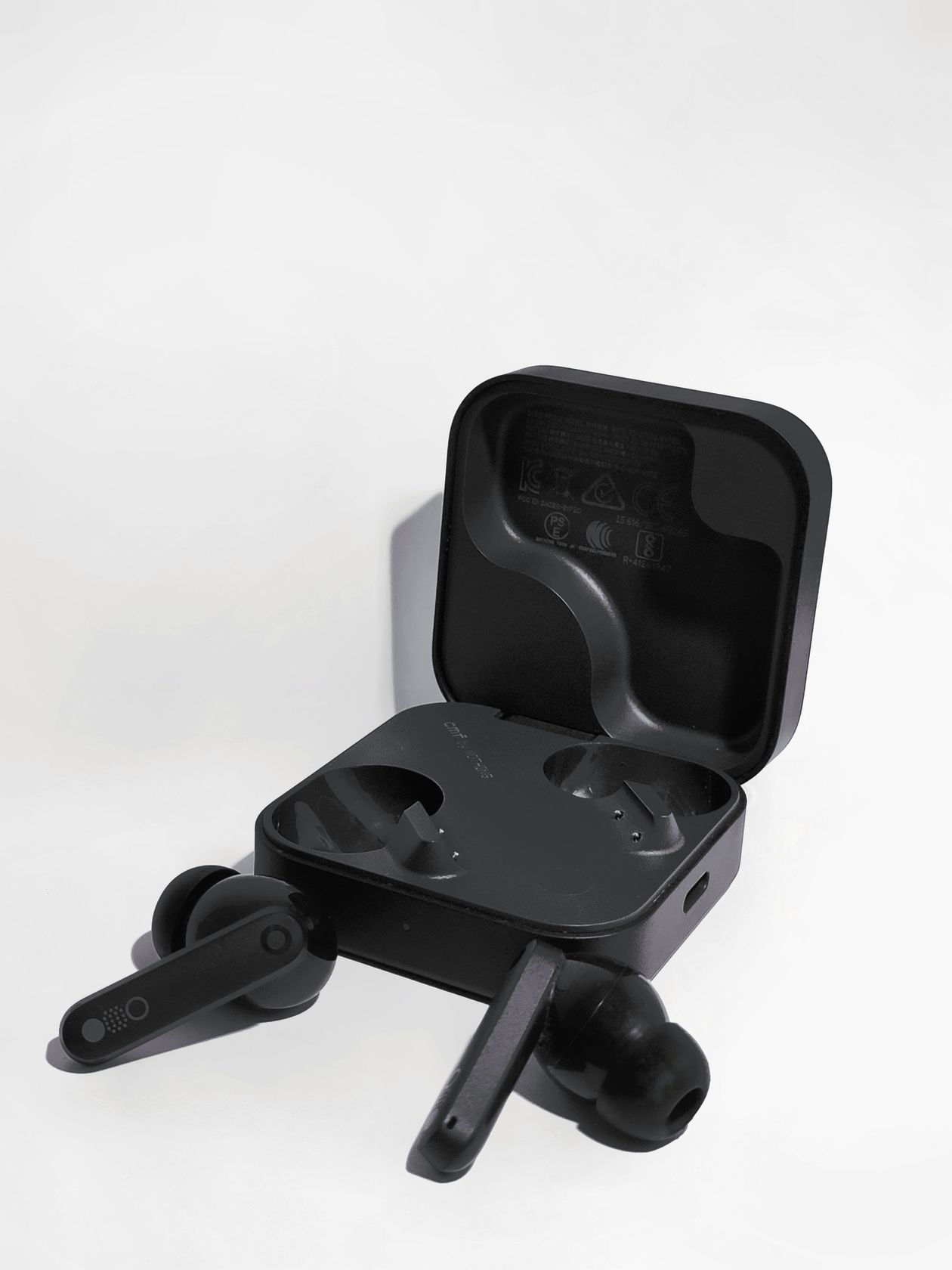 Black true wireless earbuds in an open charging case Black true wireless earbuds in an open charging case