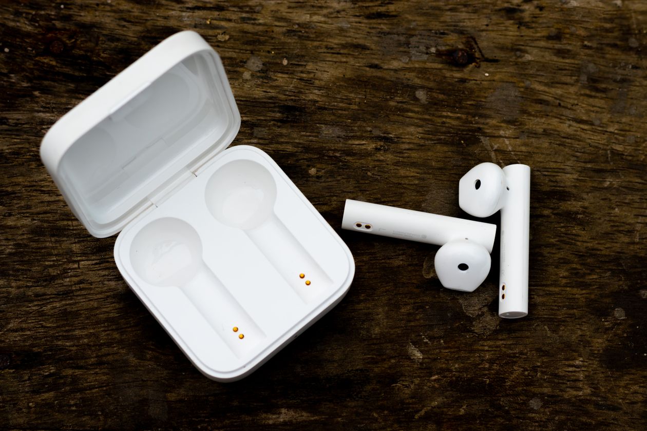 True wireless earbuds resting in an open charging case True wireless earbuds resting in an open charging case