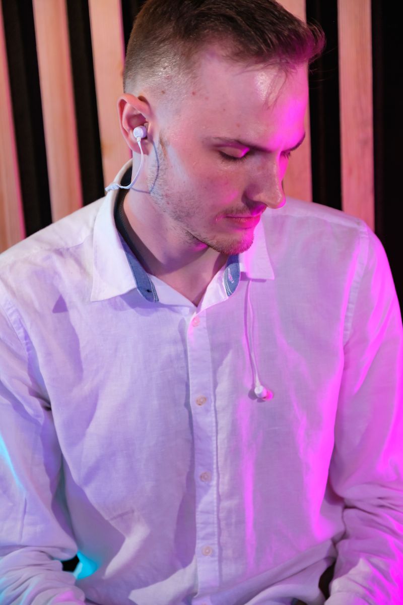 Person wearing an in-ear earphone while listening to music