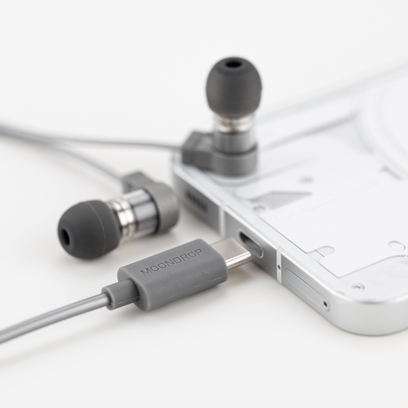 Moondrop Quark2 earpieces resting near laptop and phone Moondrop Quark2 earpieces resting near laptop and phone