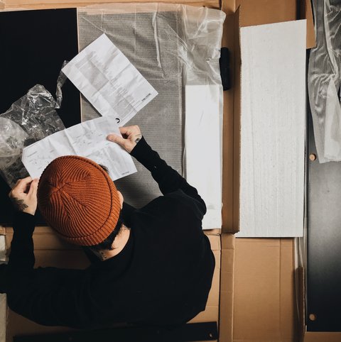 Person reading a printed instruction manual, similar to following Reolink app setup steps