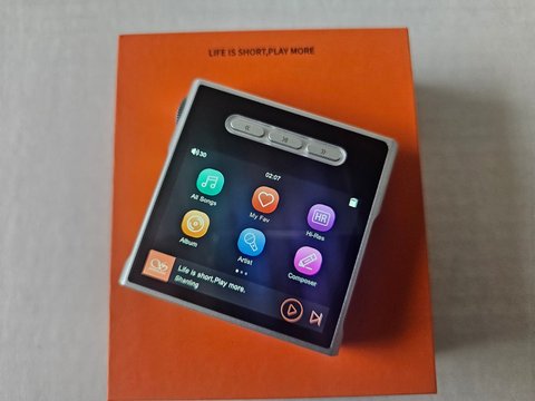 Shanling M1S resting on its retail packaging showing the home screen interface Shanling M1S resting on its retail packaging showing the home screen interface
