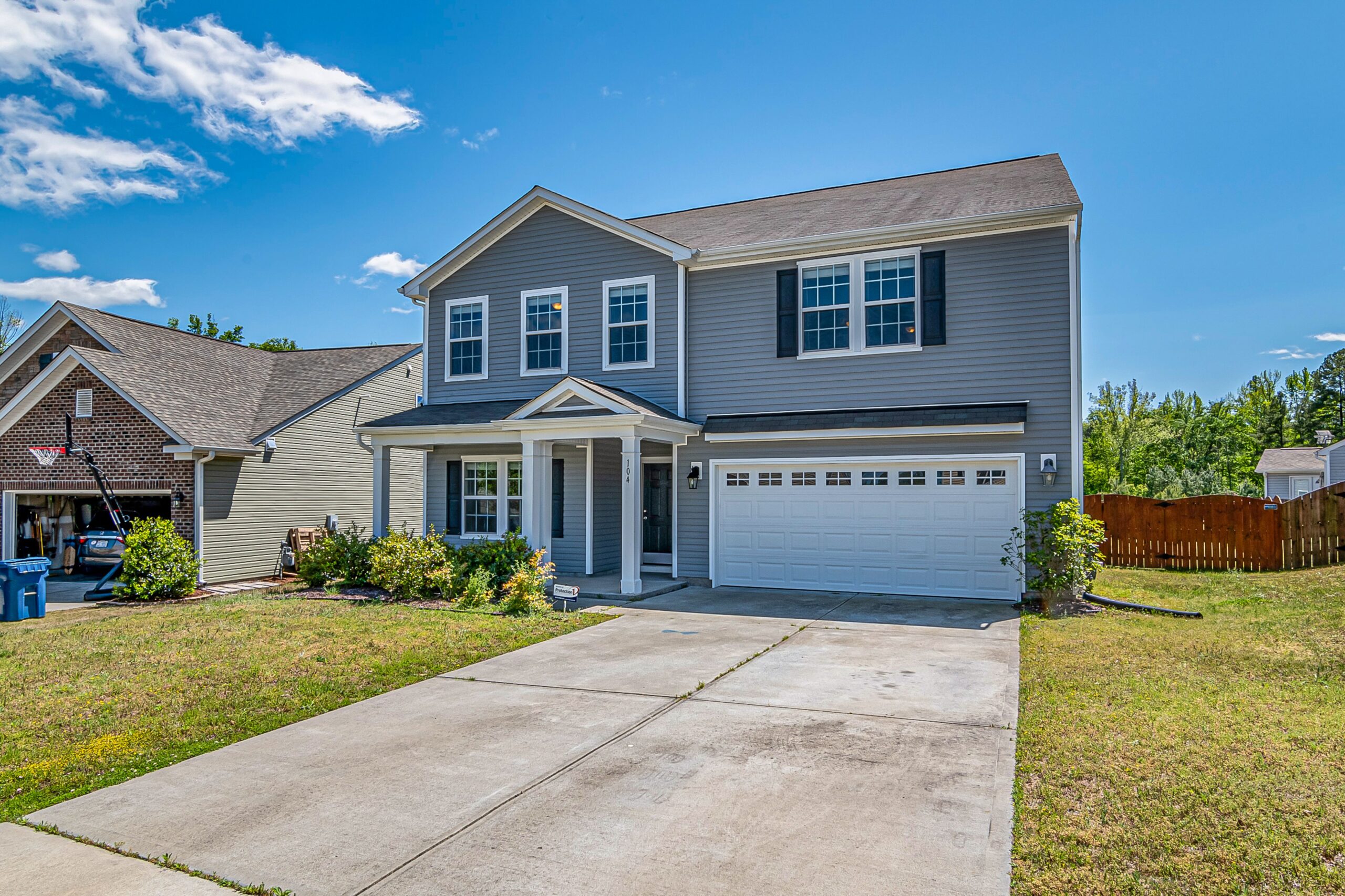 Two-story house with driveway and garage, a typical outdoor camera coverage area