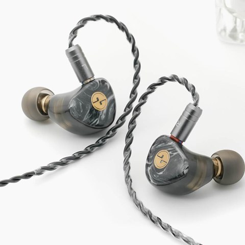 Tin HiFi T3 Plus pair with braided cable resting on a table Tin HiFi T3 Plus pair with braided cable resting on a table