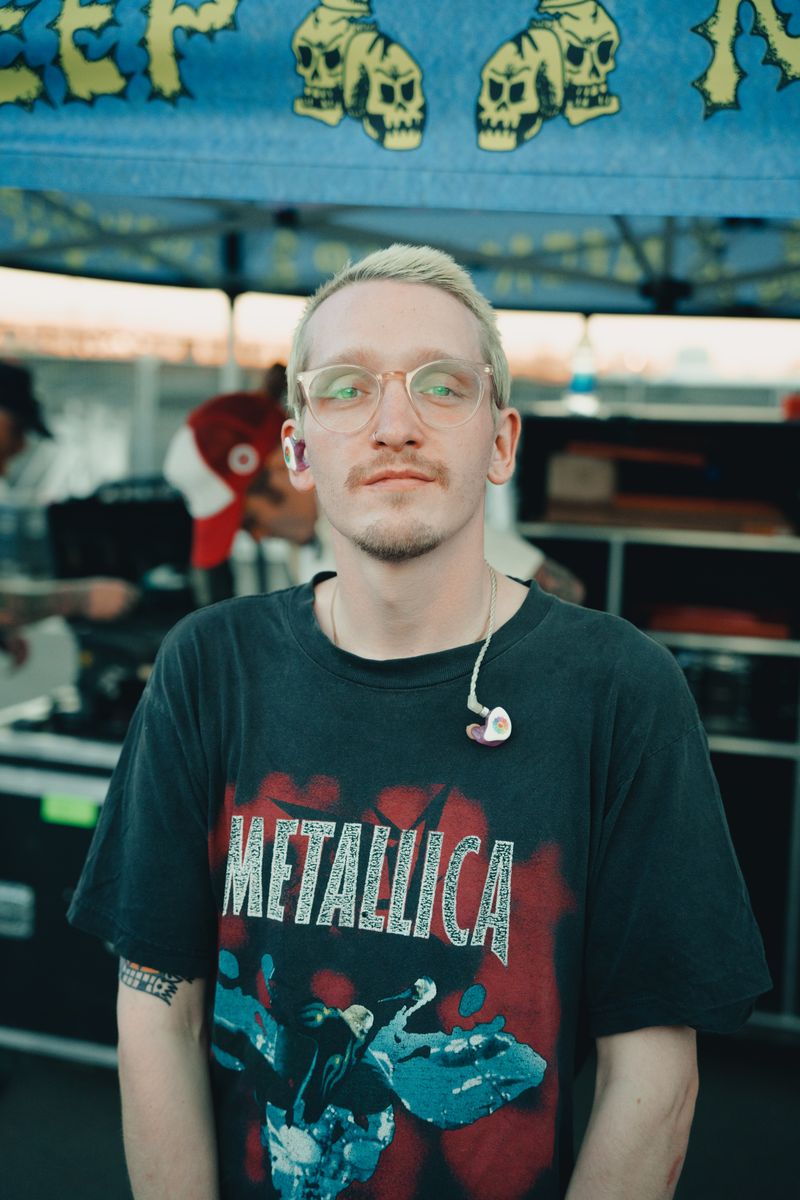 Person wearing a translucent in-ear monitor with visible cable and connector Person wearing a translucent in-ear monitor with visible cable and connector