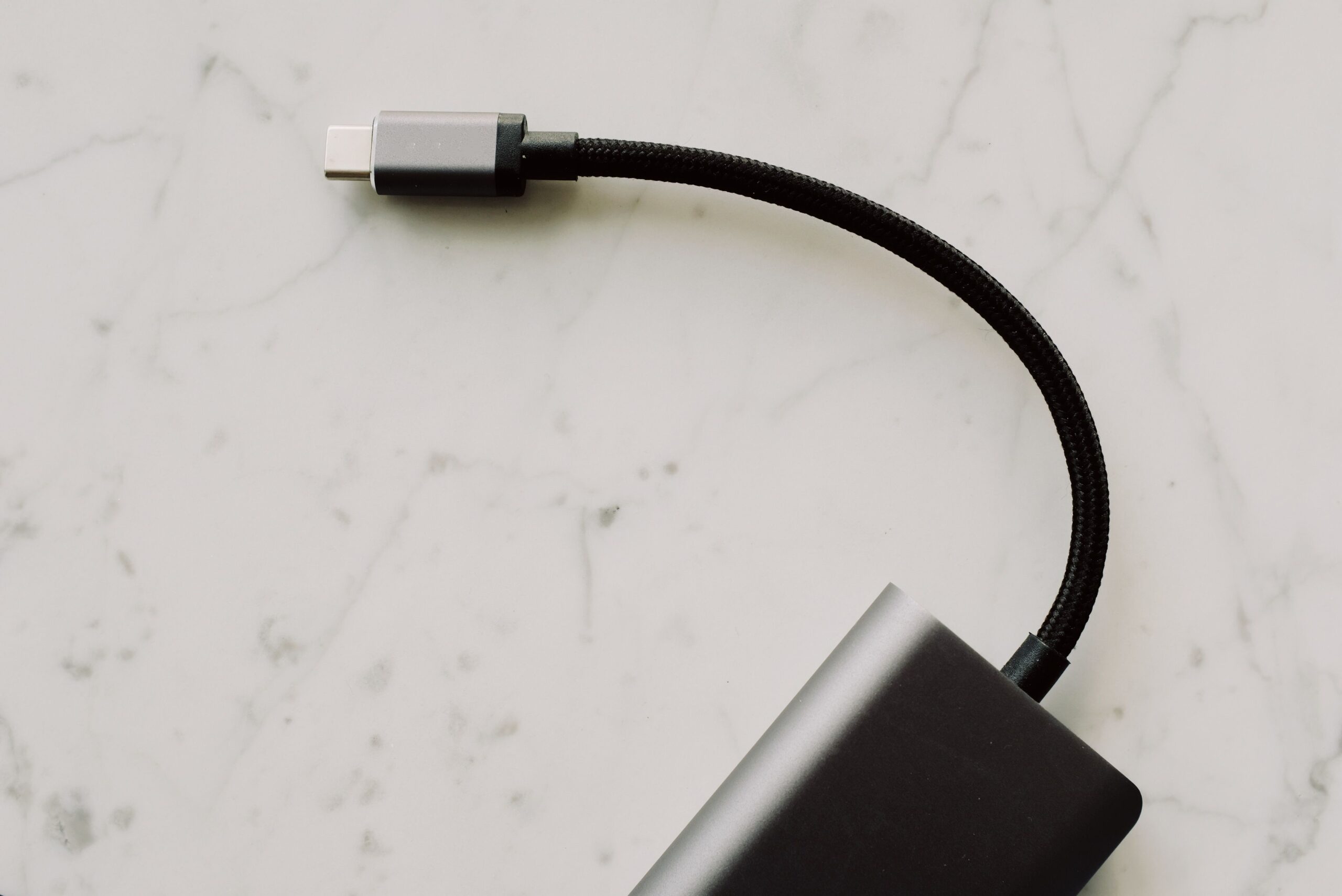 USB-C cable connected to a small portable electronic device USB-C cable connected to a small portable electronic device