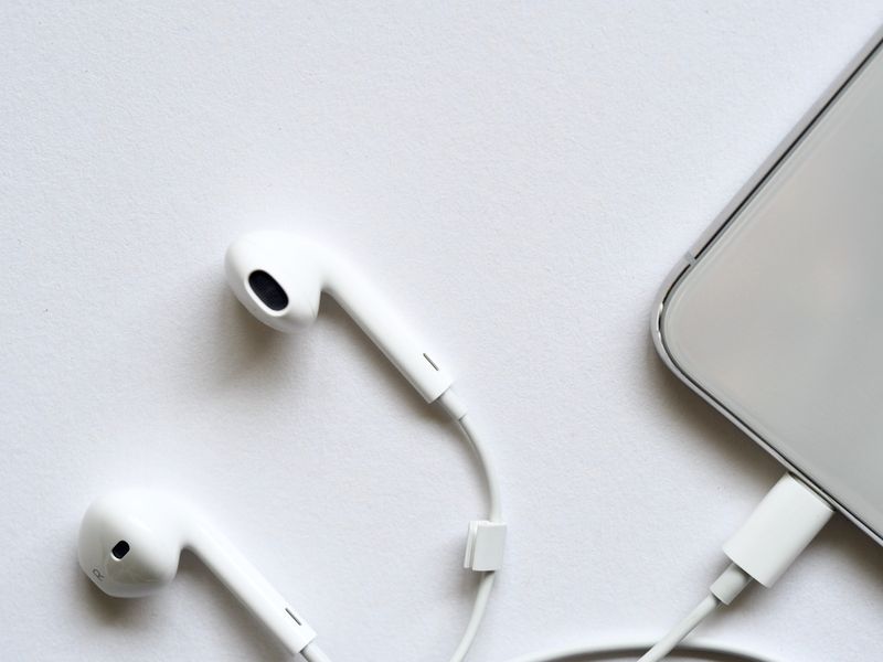 Wired in-ear earphones connected to a smartphone Wired in-ear earphones connected to a smartphone
