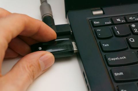 Small USB network adapter inserted into laptop port Small USB network adapter inserted into laptop port