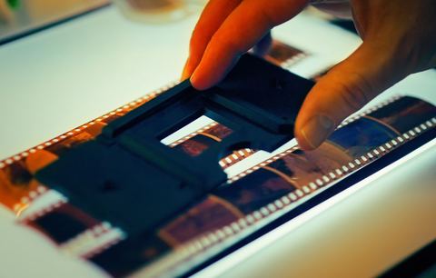 Hand holding a film negative strip for scanning Hand holding a film negative strip for scanning