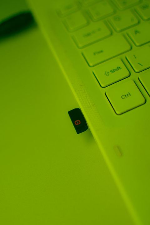 USB wireless dongle plugged into laptop keyboard edge USB wireless dongle plugged into laptop keyboard edge