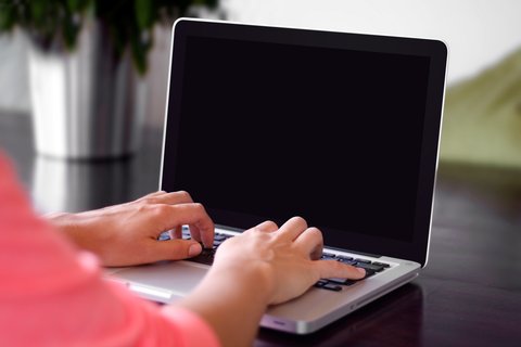 Person typing on a laptop keyboard during driver troubleshooting Person typing on a laptop keyboard during driver troubleshooting