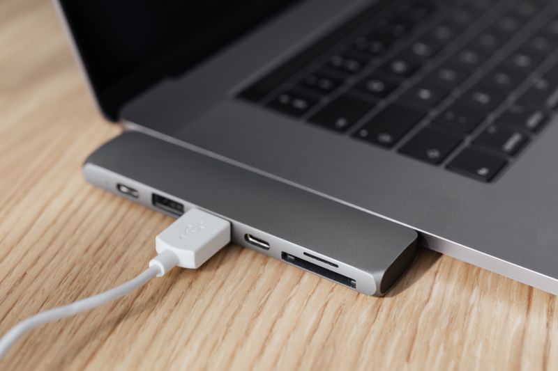 Laptop connected to a USB-C docking hub on a desk Laptop connected to a USB-C docking hub on a desk