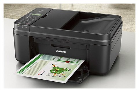 Small compact Canon inkjet printer with output tray extended on a desk setup Small compact Canon inkjet printer with output tray extended on a desk setup