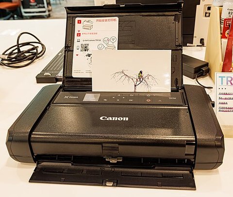 Compact Canon inkjet printer viewed from the front with paper tray and control panel Compact Canon inkjet printer viewed from the front with paper tray and control panel