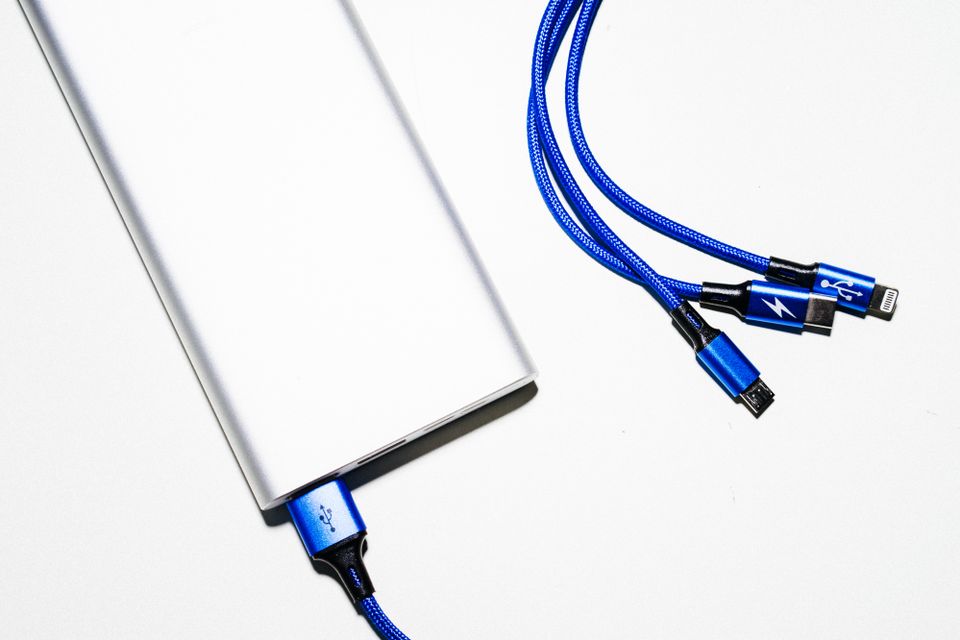 Compact power bank with USB charging cables on white background