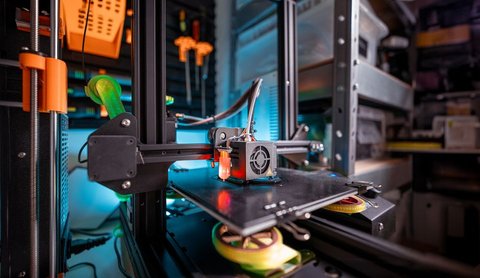 Creality Ender 3 style 3D printer connected by USB cable on a workshop bench Creality Ender 3 style 3D printer connected by USB cable on a workshop bench