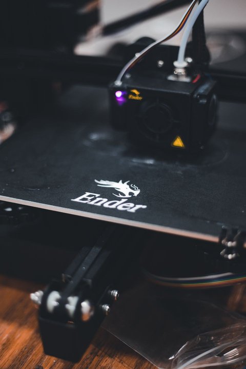 Close up of Ender printer bed and hotend showing the Ender branding on the machine Close up of Ender printer bed and hotend showing the Ender branding on the machine