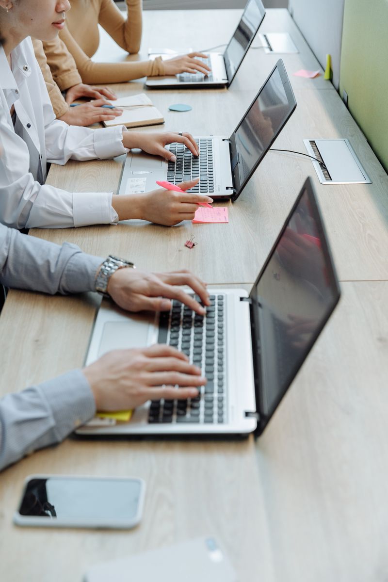 Team typing on business laptops relevant to Dell Latitude 5420 driver download context Team typing on business laptops relevant to Dell Latitude 5420 driver download context
