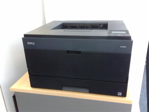 Compact Dell desktop laser printer similar to the 1130n model placed on an office shelf Compact Dell desktop laser printer similar to the 1130n model placed on an office shelf