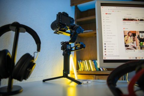 Camera mounted on a gimbal next to a monitor showing a streaming dashboard Camera mounted on a gimbal next to a monitor showing a streaming dashboard