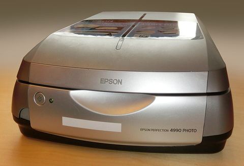 Epson flatbed photo scanner sitting on a desk next to a computer Epson flatbed photo scanner sitting on a desk next to a computer