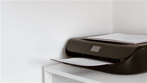 Compact home office inkjet printer positioned on a desk ready for setup Compact home office inkjet printer positioned on a desk ready for setup