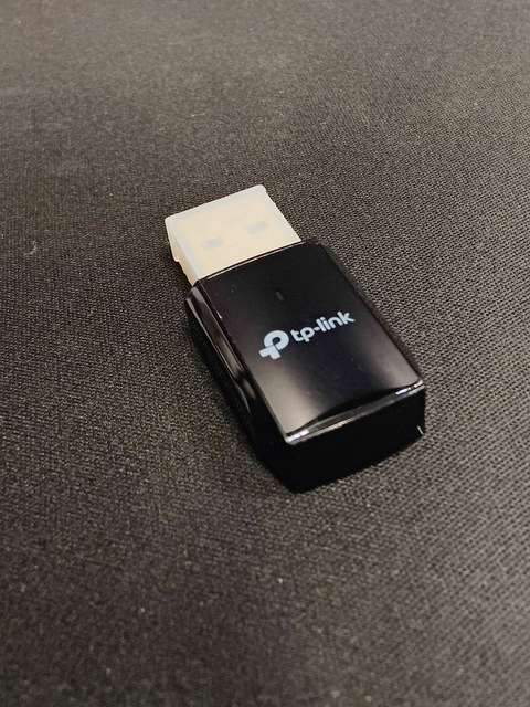 TP-Link USB Wi-Fi adapter dongle held in hand showing the small form factor TP-Link USB Wi-Fi adapter dongle held in hand showing the small form factor