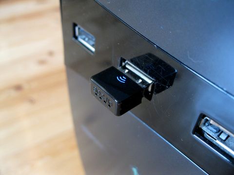 Small USB wireless network dongle plugged into a computer during setup Small USB wireless network dongle plugged into a computer during setup