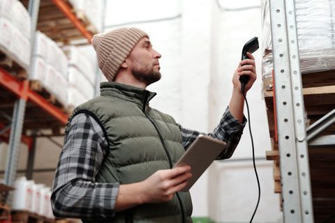 Technician scanning a warehouse shelf label with a Honeywell style scanner Technician scanning a warehouse shelf label with a Honeywell style scanner