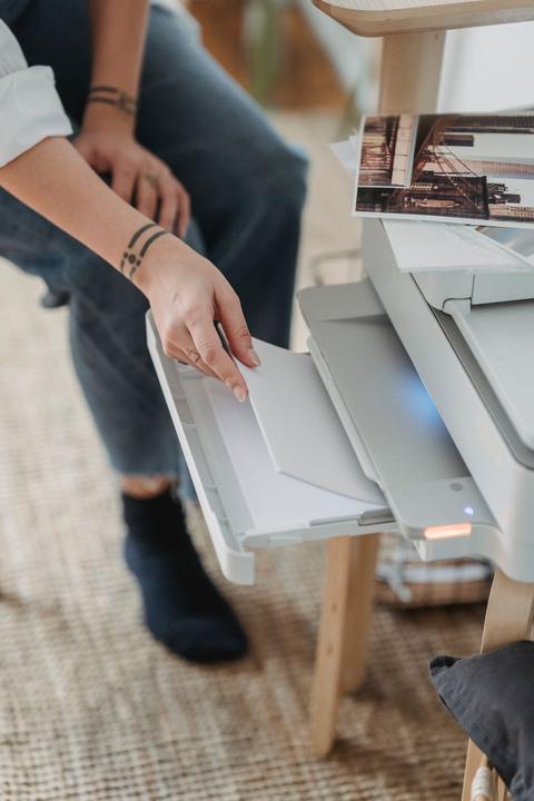 loading a sheet of paper into a small home inkjet printer tray
