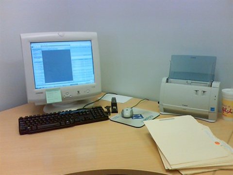 Small office desk arrangement with printer and laptop side by side Small office desk arrangement with printer and laptop side by side