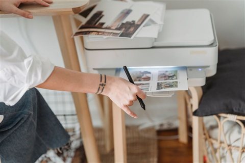 Printer producing printed photo pages illustrating typical output from an all-in-one device Printer producing printed photo pages illustrating typical output from an all-in-one device