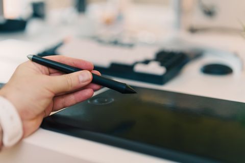 Digital artist using a graphics tablet stylus to test line pressure after driver update