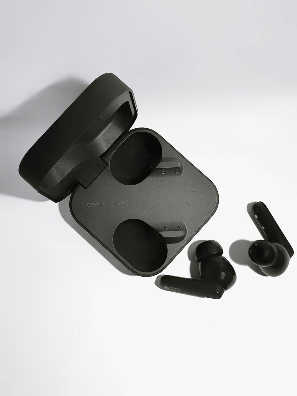 Black wireless earbuds and charging case on white backdrop Black wireless earbuds and charging case on white backdrop