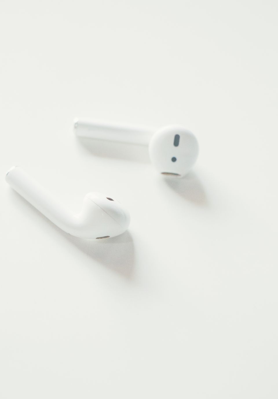 Close-up of white wireless earbuds on a white background Close-up of white wireless earbuds on a white background