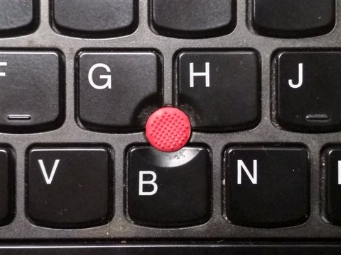 Close up of the red TrackPoint pointing stick nub between the G and H keys Close up of the red TrackPoint pointing stick nub between the G and H keys