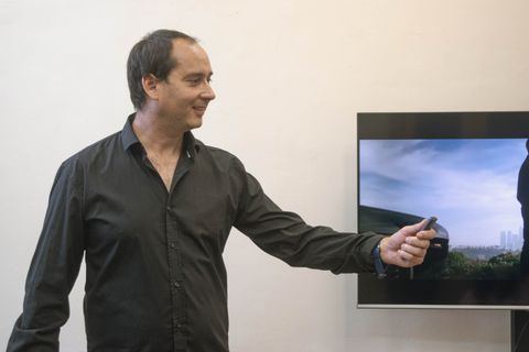 man demonstrating a slide presentation using a handheld wireless remote man demonstrating a slide presentation using a handheld wireless remote