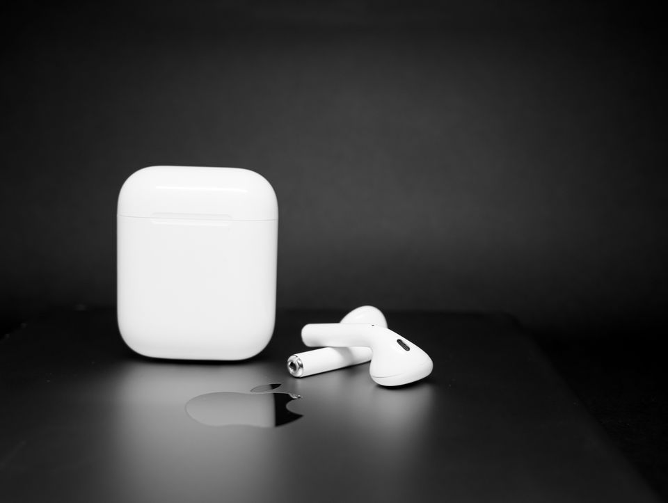 Wireless earbuds and charging case on a dark background