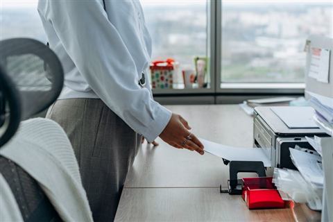 Person printing a document from a home office inkjet printer Person printing a document from a home office inkjet printer