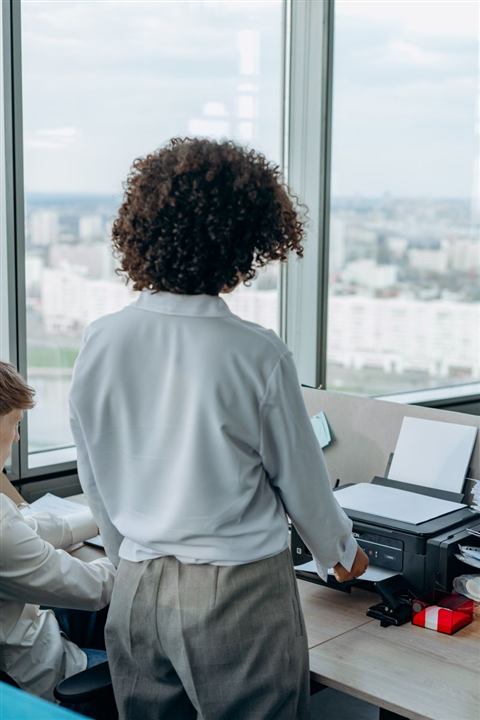 Business professionals working near an office laser printer Business professionals working near an office laser printer