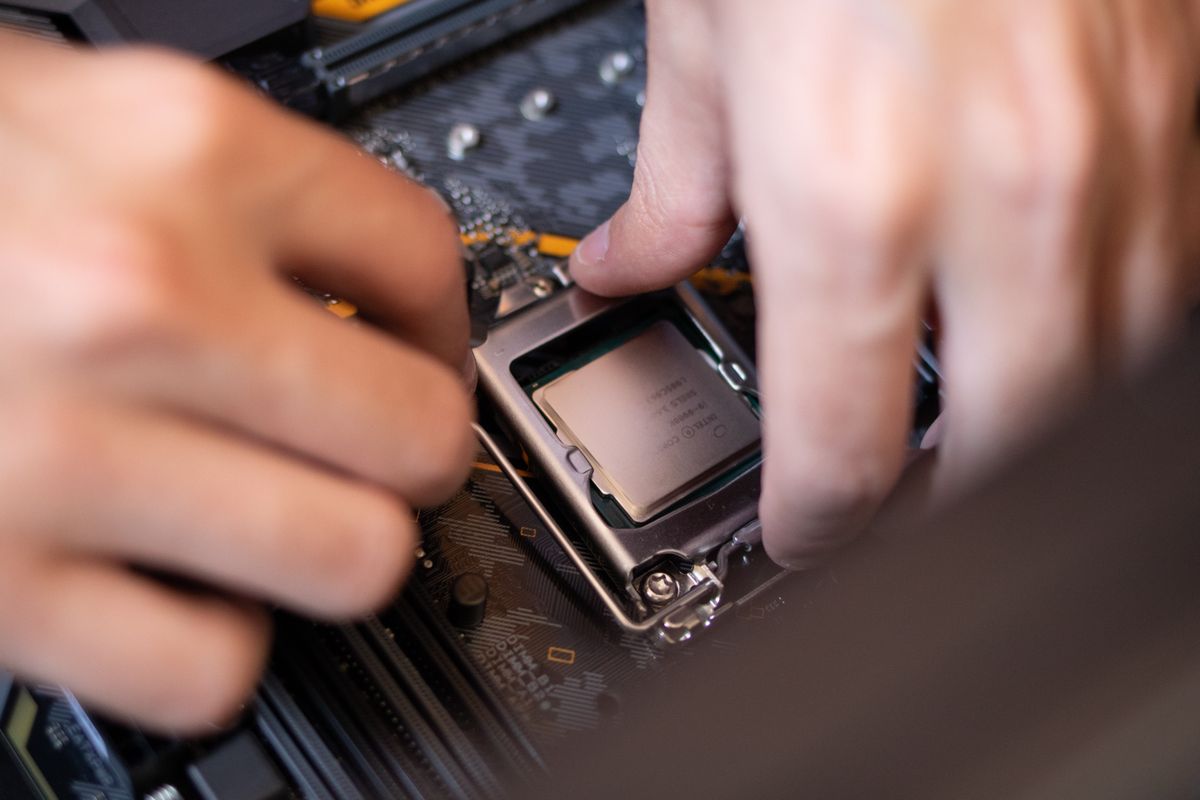 Hands installing a CPU cooler onto a motherboard Hands installing a CPU cooler onto a motherboard