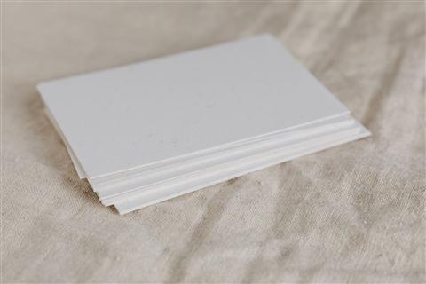 Neat stack of white printed paper next to a home office printer setup Neat stack of white printed paper next to a home office printer setup