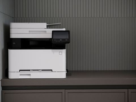 Modern all-in-one laser printer sitting on an office cabinet Modern all-in-one laser printer sitting on an office cabinet