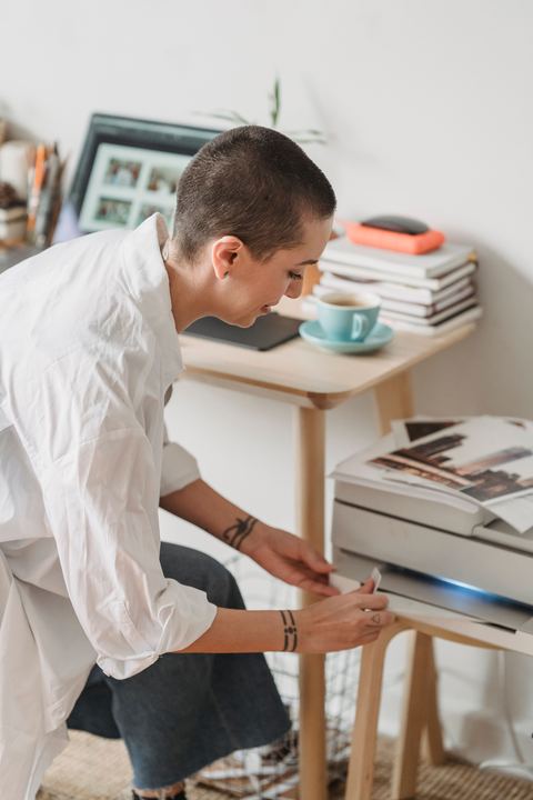 Modern home printer scanning printed photographs on a desk Modern home printer scanning printed photographs on a desk
